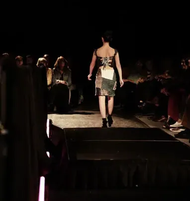 Model in a black sequin dress among the audience