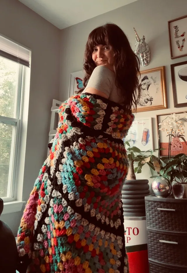 Granny-square blanket worn as a wrap